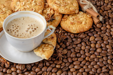 Peanut cookies and chocolate chips cookies in wicker basket on light surface and scattered coffee beans near it. Copy space for your text.