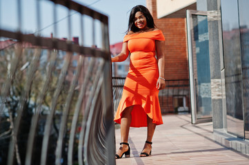 African american woman model xxl in orange dress.