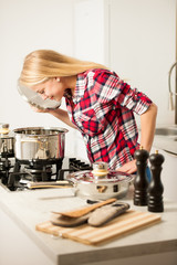 Beautiful young woman in kitchen cooks a delicious meal