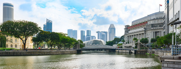 Singapore, panoramic view from river bank to Cavenagh bridge with down-town skyscrapers in...