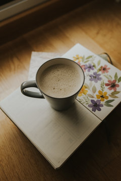 Cup of warm drink on book