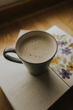Cup of warm drink on book
