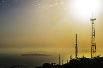 Silhouettes of telecommunications towers at sunset