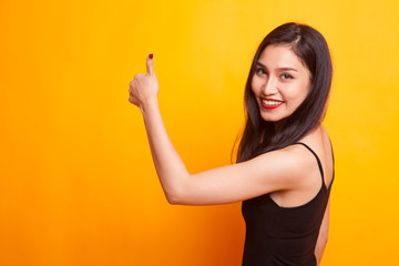 Young Asian woman turn back thumbs up.