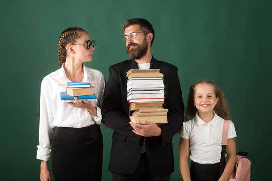 Back to school and home schooling. Literature lesson and reading grammar book. School time of sisters and father in library. Education in knowledge day. Teacher man and girls hold book pile at school