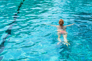 Back view of beautiful woman in swimming pool