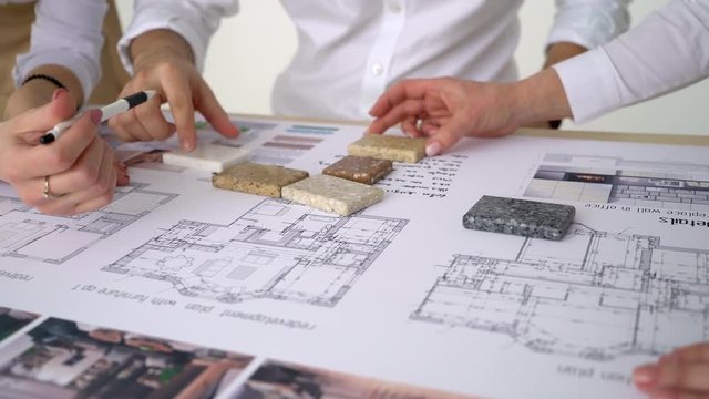 Close-up shooting of drawing Builders make repairs in apartment in new house, check parameters. Close-up Shot man holds large white sheet, photo with architectural design of building, furniture. 4 k