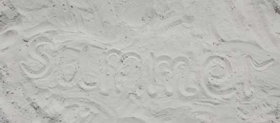 Summer written in the sand on the beach