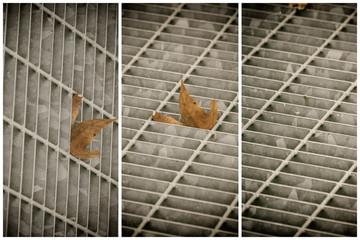 Square metal hatch in urban pavement, sewer manhole cover with marking lines and leaf inside