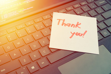 Thank you message concept written post it on laptop keyboard