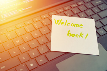 Welcome back message concept written post it on laptop keyboard