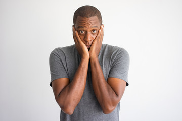 Portrait of shocked and puzzled African American. Stressed black man in casual wear surprised with...