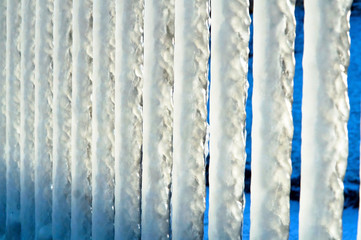 The metal fence is covered with ice. Winter on the Baltic sea. Icing on the seafront. The pier in ice.