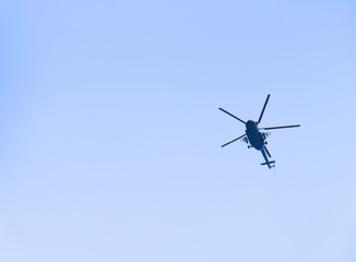 The military helicopter in the blue sky above me high. High in the sky aviation.