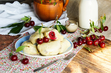 dumplings with cherry, on the old wooden table, rustic style