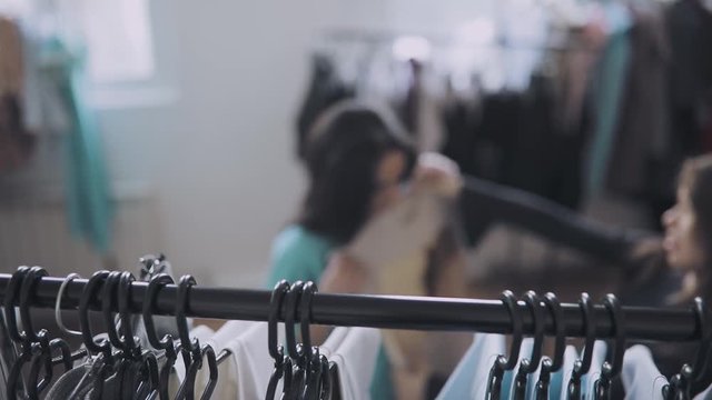 Woman choise clothes in shop, merchandiser help her