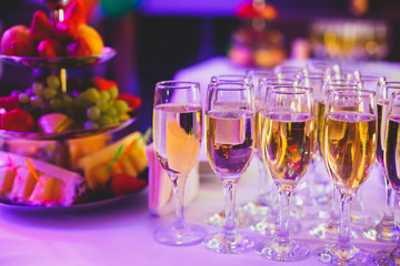 Beautiful row line of different colored alcohol cocktails on a party,  on decorated catering bouquet table
