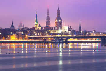 Obraz premium Old Town of Riga and River Daugava at night, Riga Cathedral, Saint Peter church and Riga castle in the background, Latvia