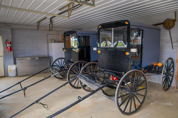 Indoor view of Amish black carriage or buggy parked inside of a garage of a house in Lancaster...