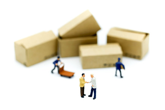 Miniature people : businessmen hand checking, standing in front of  Worker and box using as background shipping, rent container, business concept.