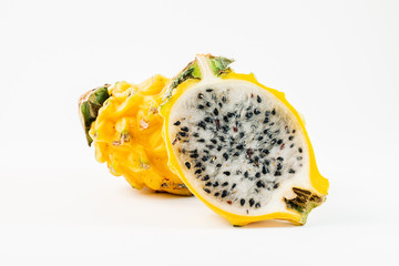 Two yellow dragon fruits on a white background.  One of the fruits is sliced in half.