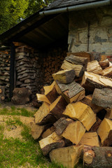 pile of fuel firewood stacked in front of a house