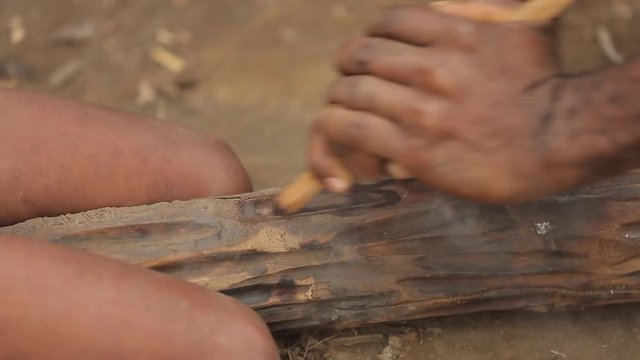 Adult and child use a traditional hand drill to get a fire to Vanuatu. The tribe fires with sticks. Tanna Island in Vanuatu. May 2016