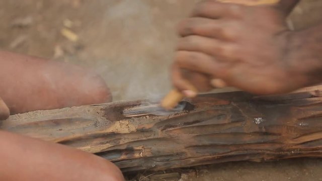 Adult and child use a traditional hand drill to get a fire to Vanuatu. The tribe fires with sticks. Tanna Island in Vanuatu. May 2016