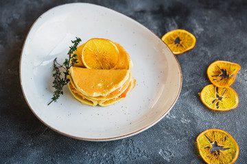 Pancakes with salmon fish in white plate and orange citrus. Tasty food.