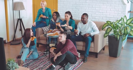 Friends sit and watch TV, discuss what's happening on TV, laugh, express emotions, eat pizza