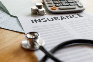 Health insurance form with money,passbook ,calculator and stethoscope concept for life planning