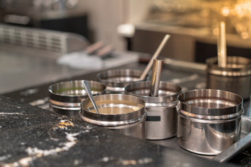 Food ingredients on stainless containers near hot pan in restaurant
