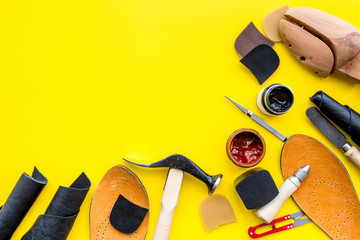 Clobber tools. Hummer, awl, knife, sciccors, wooden shoe, paint and leather. Yellow background top...