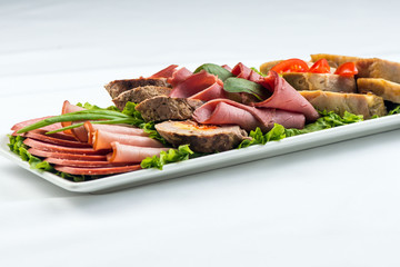 meat rolls with ham, cheese and greens on white background