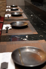 A set of ceramic plate with black chopstick  on black granite counter table