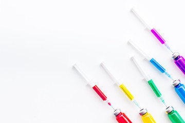 Syringe with colored drug. Injection concept on white background top view copy space pattern