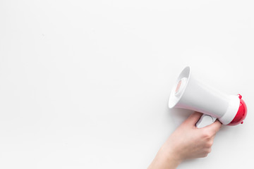 Attract attention concept. Megaphone in hand on white background top view copy space