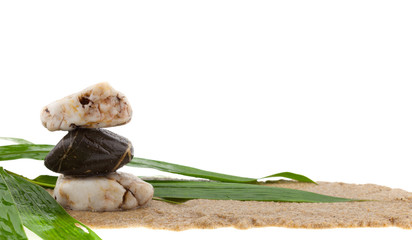stack of stone and bamboo leaves on sand,white background.