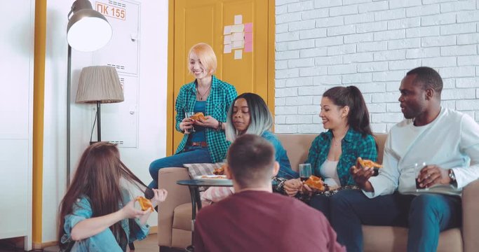 Friends eat pizza, drink drinks and tell interesting stories