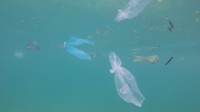 Plastic pollution in ocean environmental problem. Plastic bags, bottles cups and straws dumped in sea 