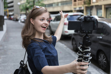 Camera recording a young caucasian female blogger gesturing while making a video