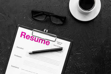 Recruitment. Select employees. Resume near coffee, glasses on black background top view copy space