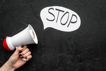Demand to stop concept. Megaphone near cloud with word stop on black background top view space for...