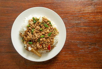 Thai food, Stir-fried pork with basil leaves on wooden background with space for text