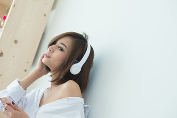 young woman listening music with wireless headphone, half latina and half asian