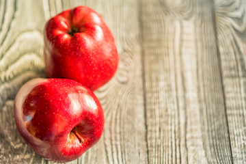 Red juice ripe apples on wooden background