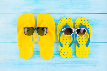 Colorful yellow flip flops with sunglasses for summer beach holidays