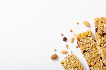Energy bar of muesli with nuts, berries and oat flakes on a white background. Healthy food, granola for breakfast. Top view.