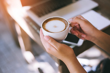 Woman holding warm mug with fresh coffee