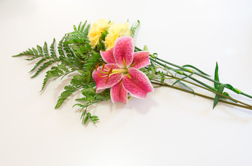 Bouquet of asiatic lilies and fern on white